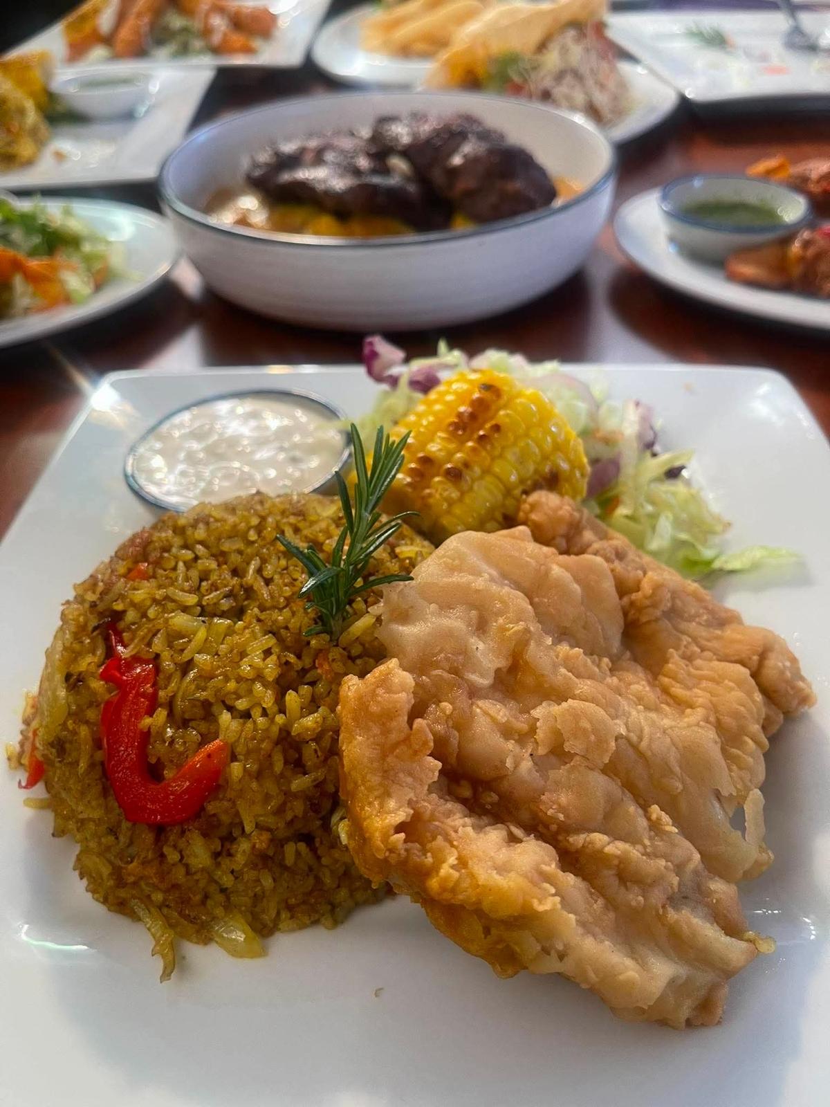 Crispy fried fish with spiced rice and grilled corn