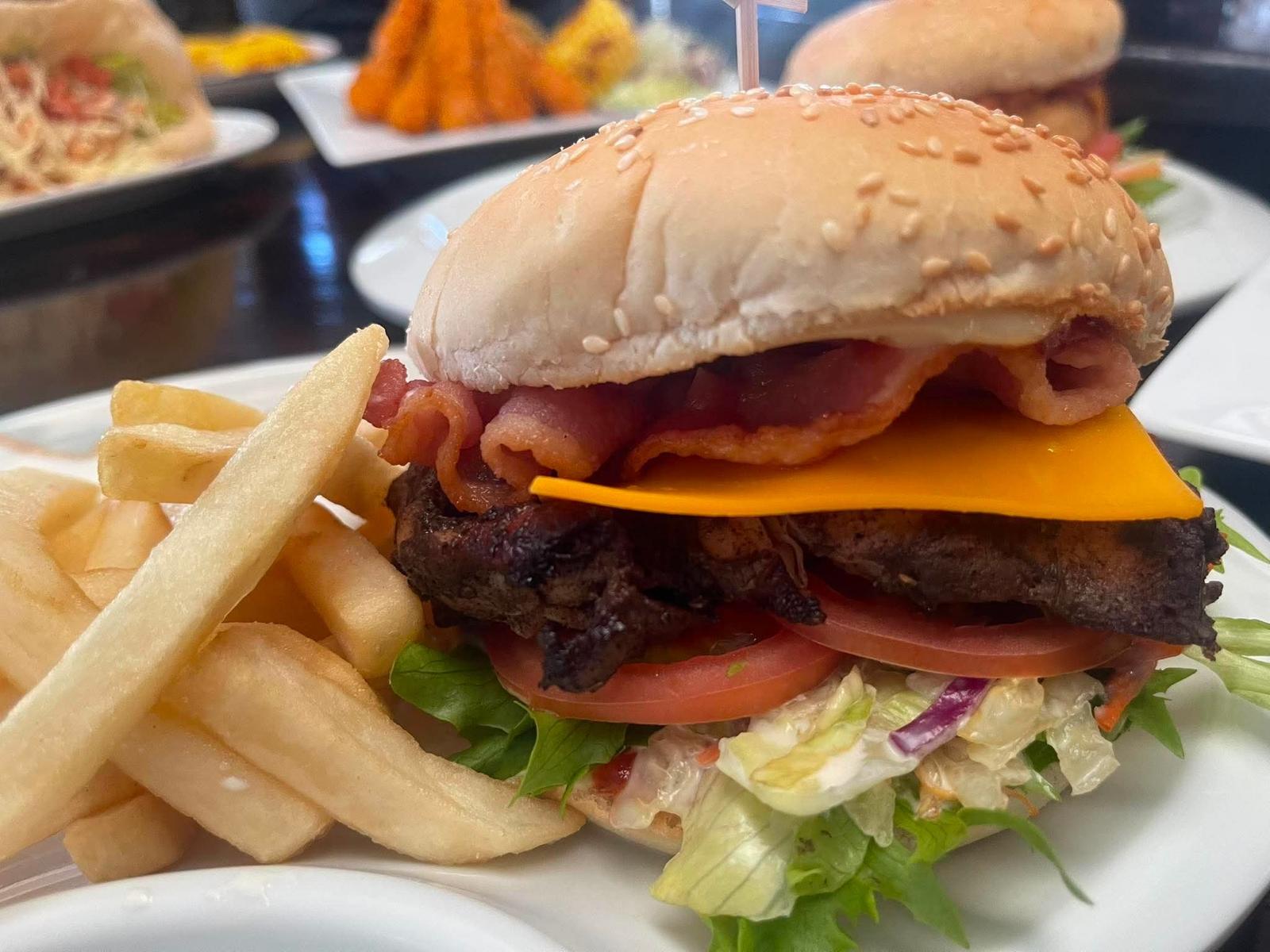 Caribbean cheese burger with bacon and fries
