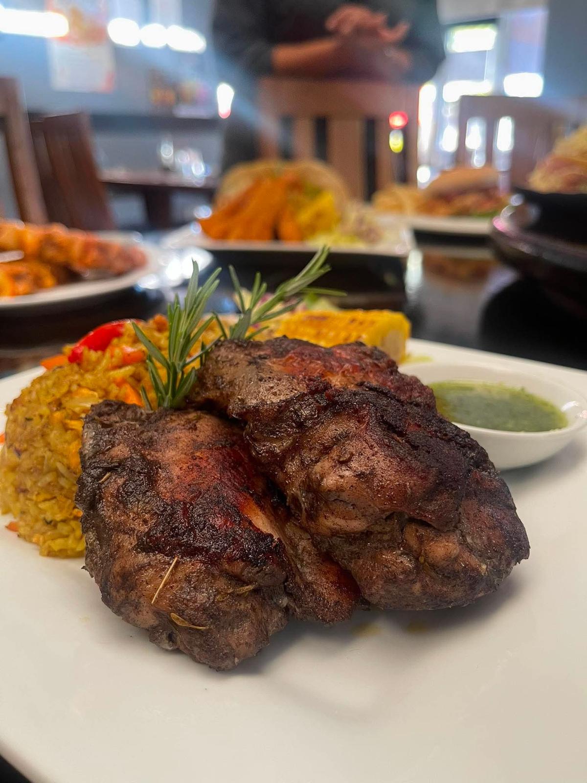 Close-up of jerk chicken with rosemary garnish