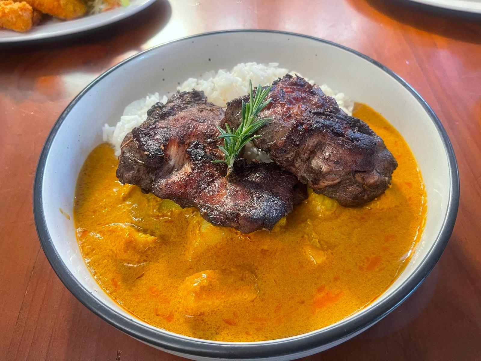 Jerk chicken on coconut curry with rice