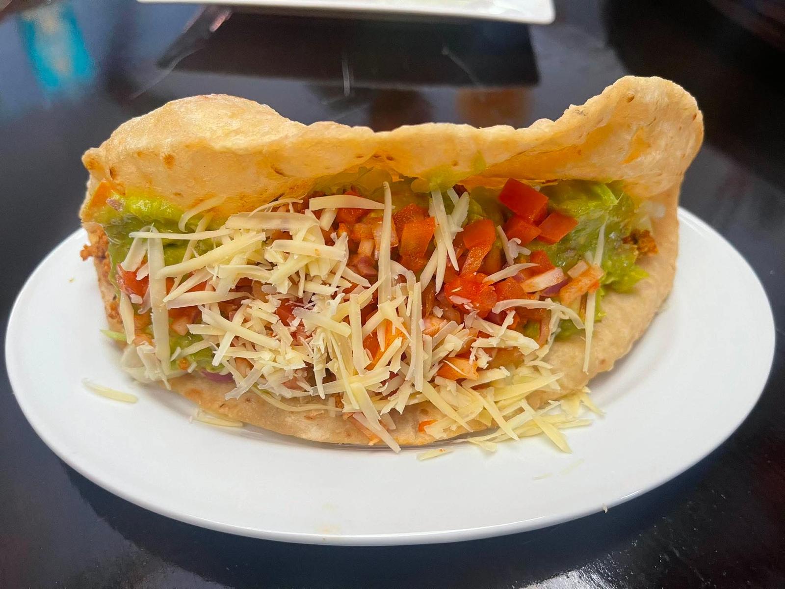 Loaded Caribbean taco with guacamole, cheese and salsa